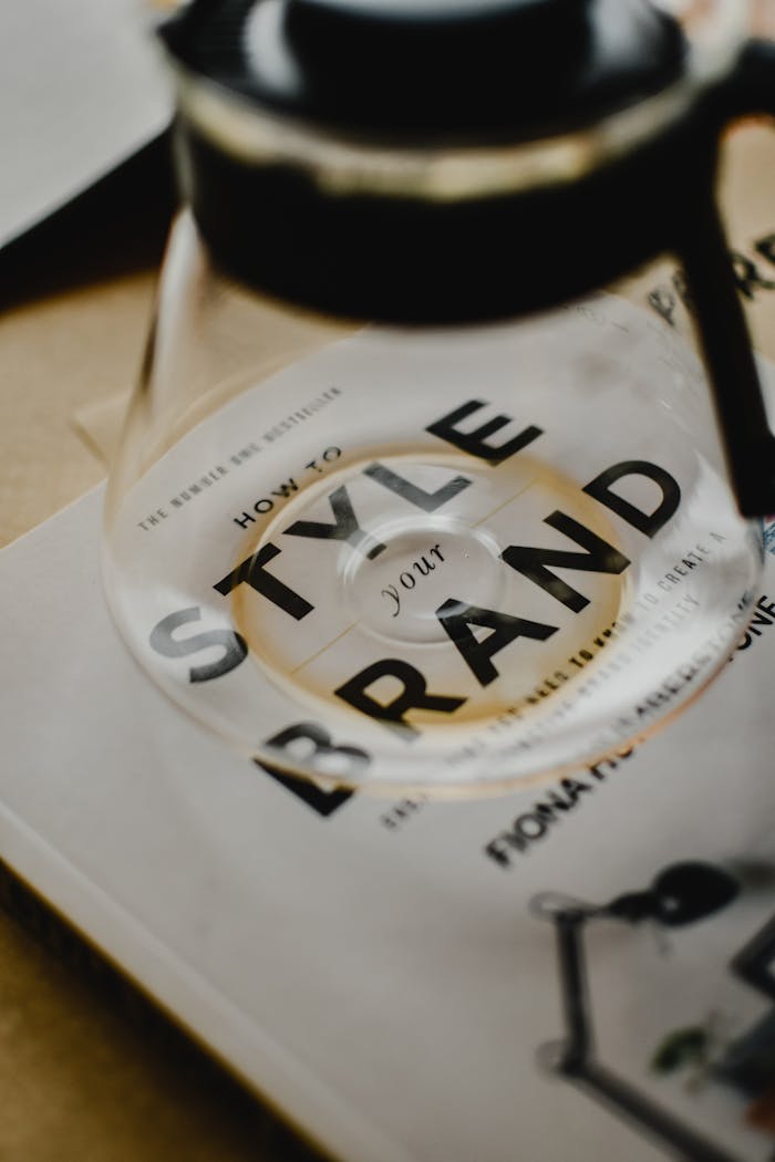A coffee pot rests atop a book titled How to Style Your Brand, capturing the essence of creative branding.